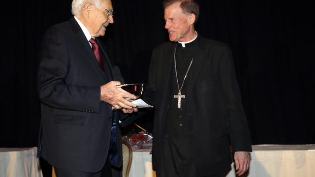 Vârstnicul L. Tom Perry din Cvorumul celor Doisprezece Apostoli primeşte un premiu umanitar de la Episcopul John C. Wester al diocezei catolice din oraşul Salt Lake City, 6 noiembrie 2014.