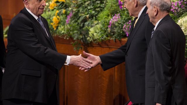 Preşedintele Thomas S. Monson dă mâna cu vârstnicul L. Tom Perry după sfârşitul unei sesiuni a Conferinţei Generale, aprilie 2013.