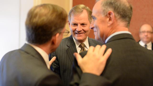 Blair Treu, regizorul filmului "Faceți cunoștință cu mormonii", Gary E. Stevenson, episcopul care prezidează al Bisericii lui Isus Hristos a Sfinților din Zilele din Urmă, și Cliff Holtz, președintele Serviciilor Umanitare ale Crucii Roșii din Statele Unite, se salută unul pe celălalt înainte de începerea evenimentului în cadrul căruia Biserica a făcut o donație Crucii Roșii din Statele Unite. 